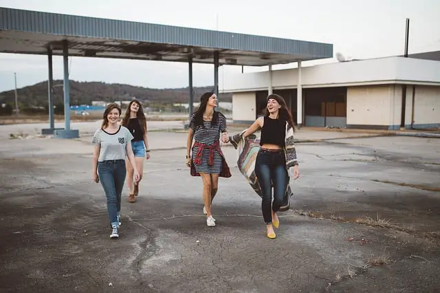 four girls are going on foot and smiling