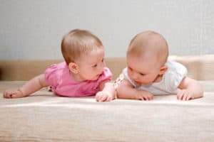 two babies are looking at the floor