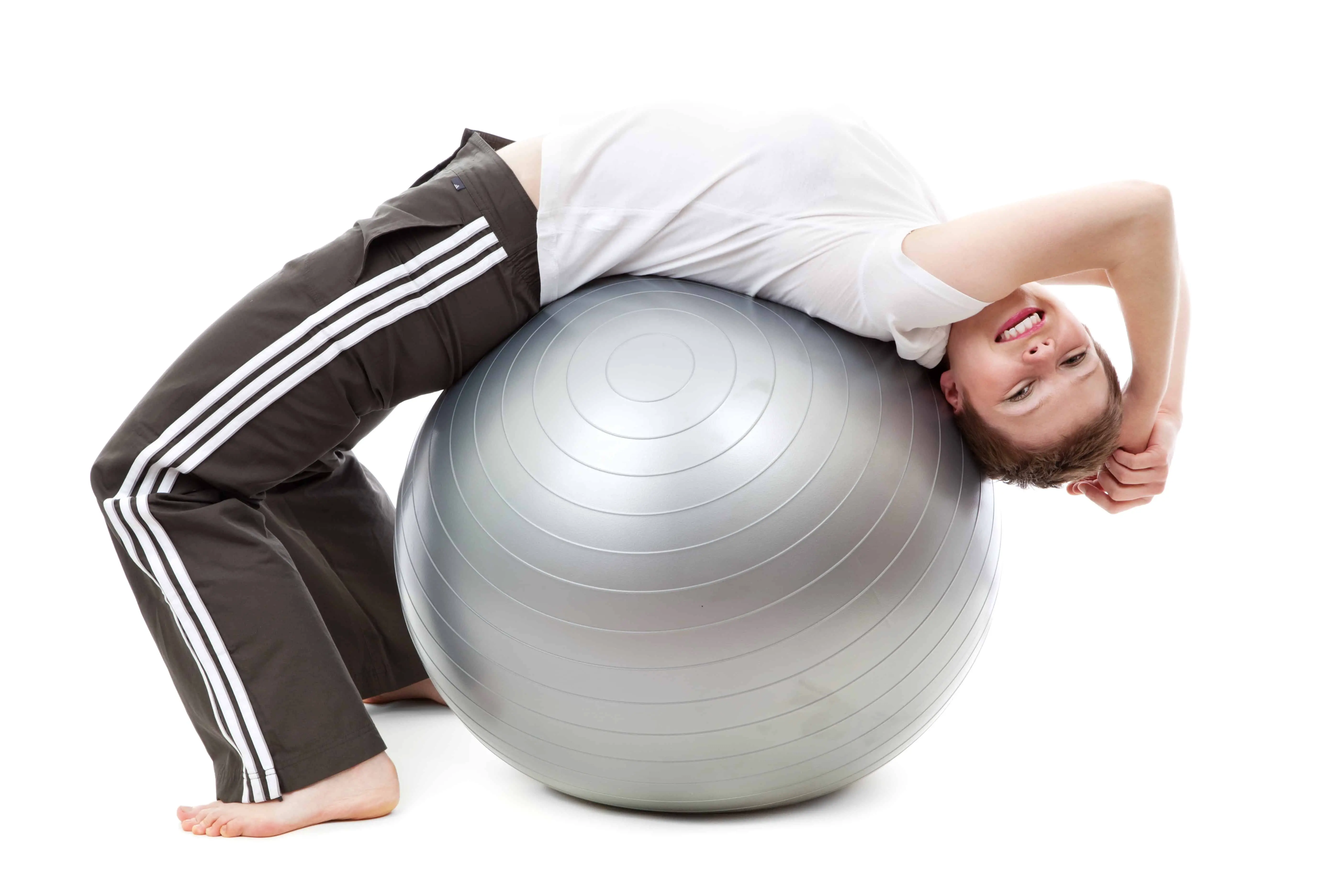 a girl is laying back on a silver yoga ball