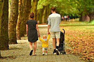 mom baby dad walking